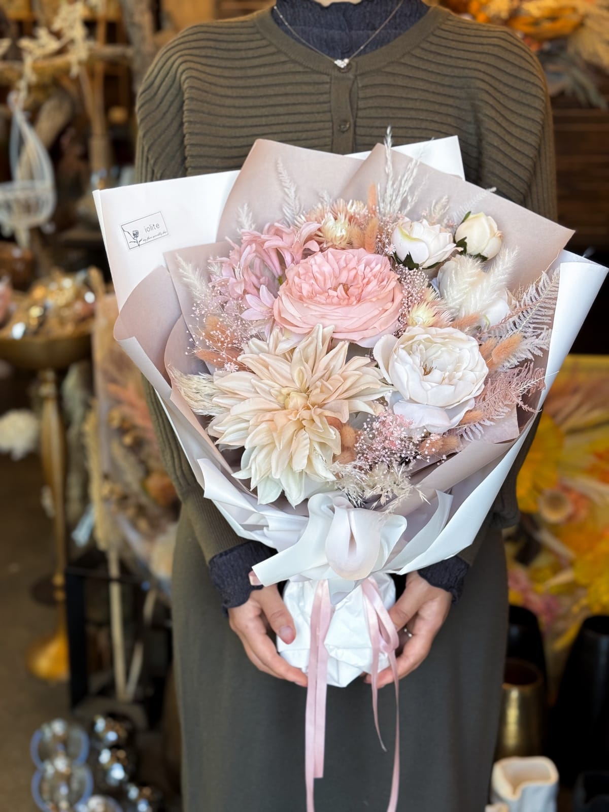 淡いピンクの花材をラッピングしたドライフラワーの花束